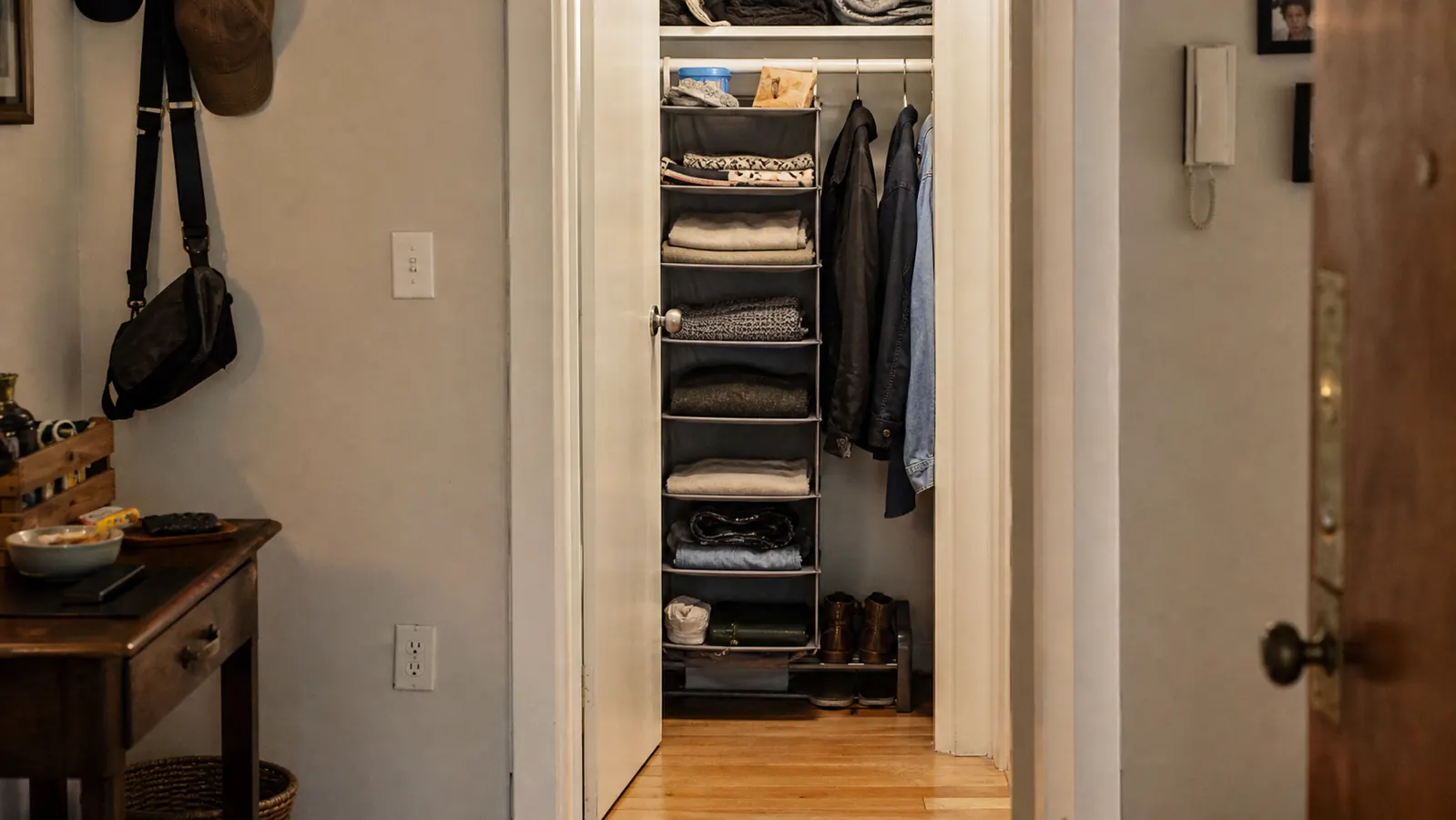 Family hallway closet door left open, tidy and uncluttered, floor visible for the first time